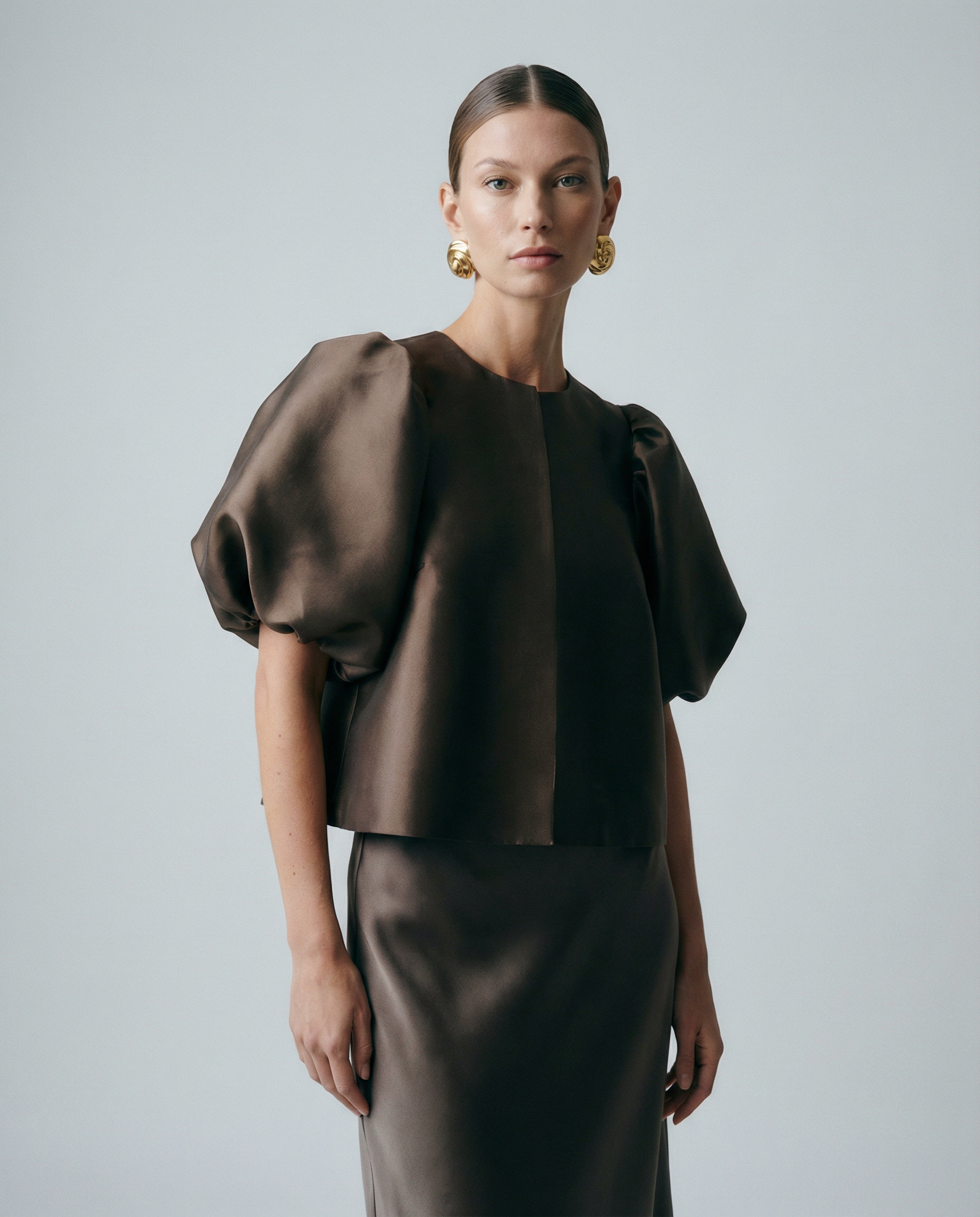 Dark brown satin blouse with short puff sleeves, crew neck, and center-front seam
