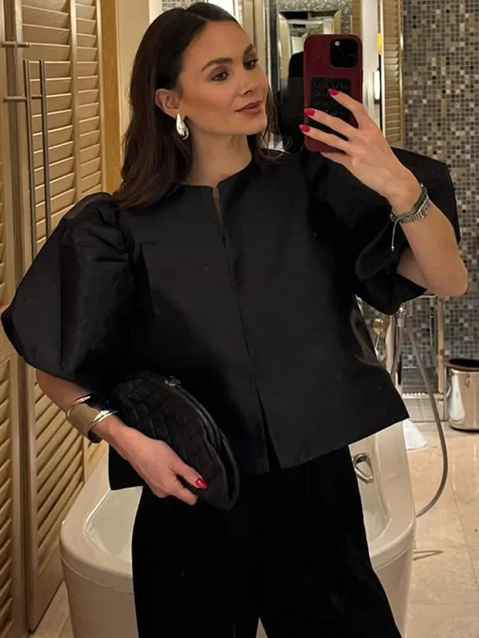 Black satin blouse with short puff sleeves and hidden button front