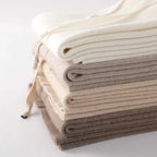 Folded knit lounge pants fabric stacks in white, light gray, and dark gray shades