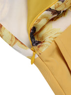Close-up of sunflower halter tie and yellow belt detail on the romper