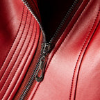 Crimson red leather jacket detail with silver zipper and stitched paneling