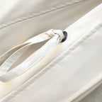 Trench coat drawstring waist detail with tied cord and round black grommet