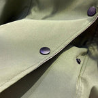 Trench coat chest and lapel area with dark button placket and green outer fabric