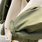 Two-tone trench coat sleeve and inner lining with green outer and cream panel