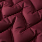 Rose red quilted fabric close-up with stitched panels and smooth finish