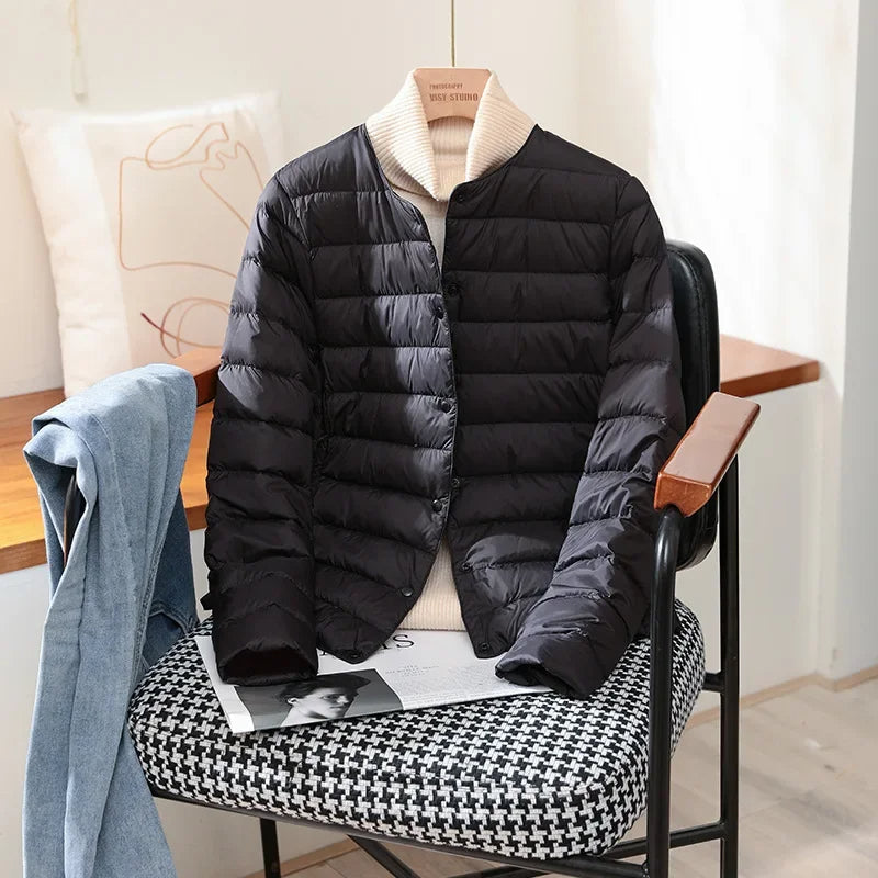 Lightweight quilted jacket in black with ribbed stand collar and snap front