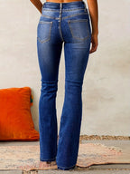 Denim blue high-waisted flared jeans, back view with rear pockets and stitched seams