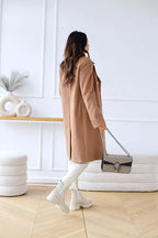 Camel brown double-breasted wool coat from back view, long sleeves, side slit styling