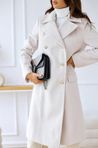 White double-breasted wool coat with gold-tone buttons and lapels, front close-up