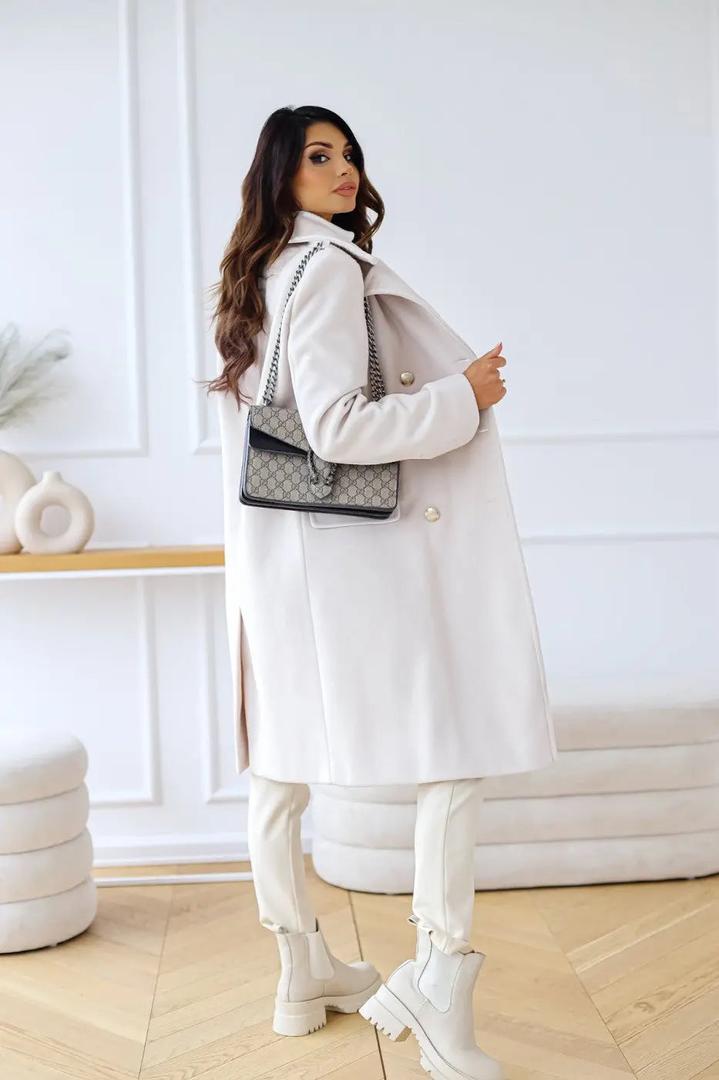 White double-breasted wool coat with gold-tone buttons and shoulder seams, side view