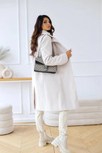 White double-breasted wool coat with gold-tone buttons and shoulder seams, side view