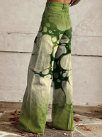 Wide-leg jeans with green abstract print, back view from hips to hem