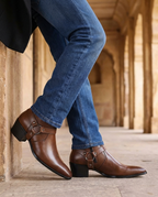 Brown leather ankle boots with buckle strap, worn with blue jeans, block heel.