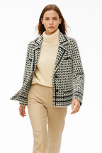 White and black houndstooth knit jacket with notched lapels and button details.