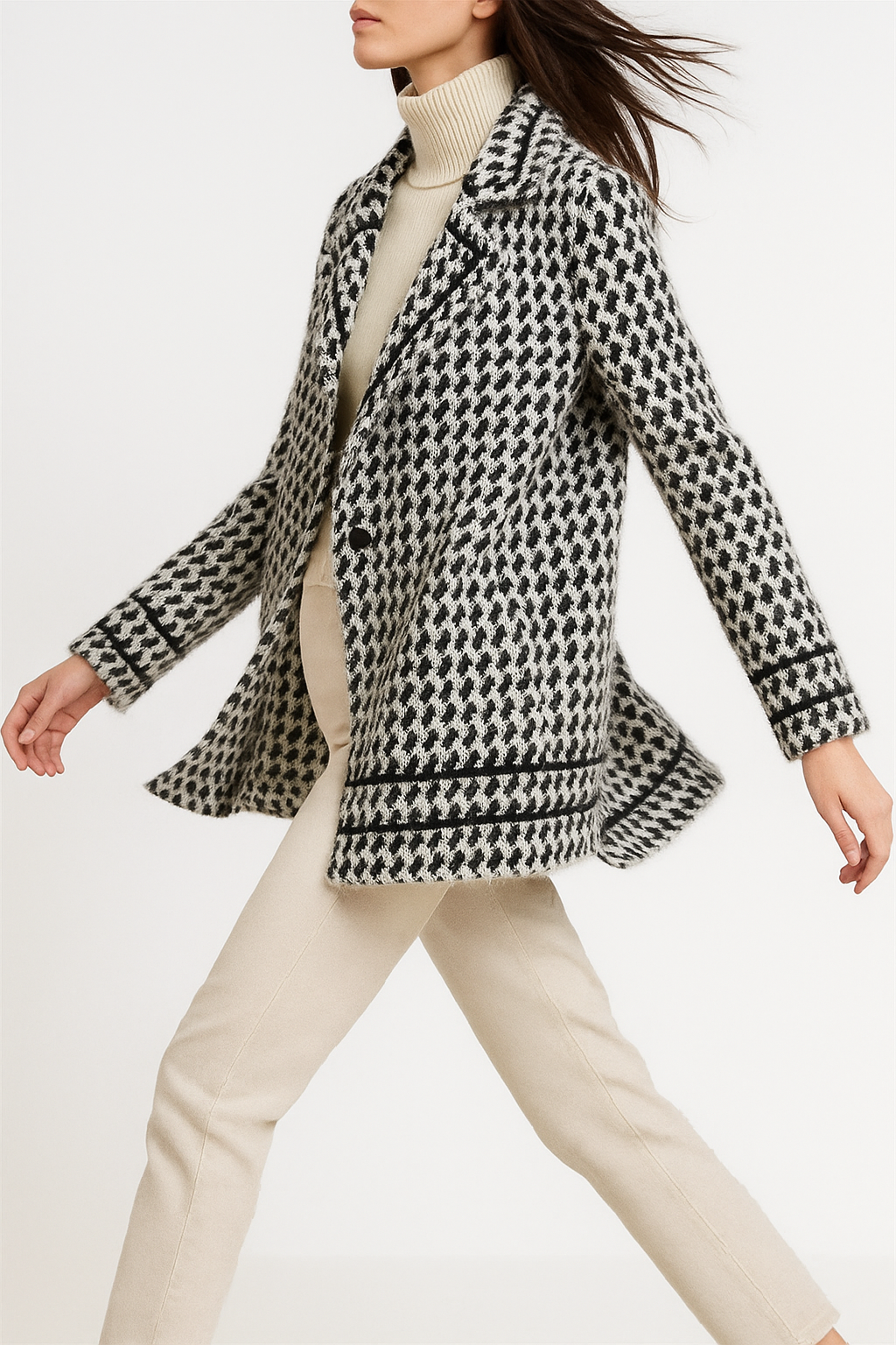 White and black houndstooth knit jacket with notch lapels and ribbed cuffs.